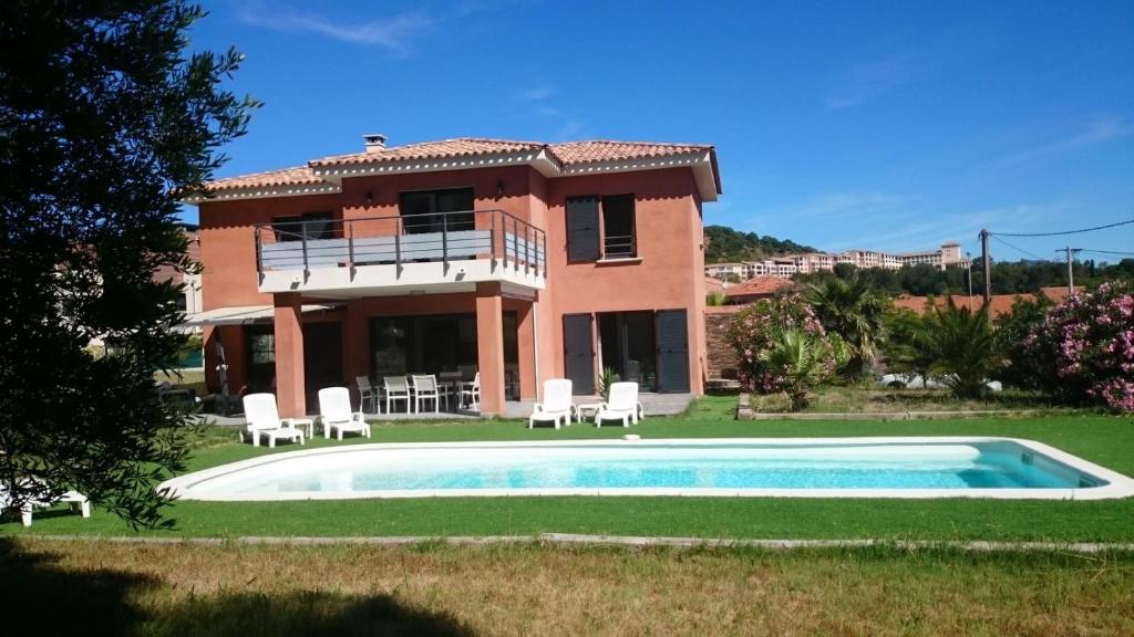 a villa with a swimming pool in front of a house at Villa Cap Dramont in Saint-Raphaël