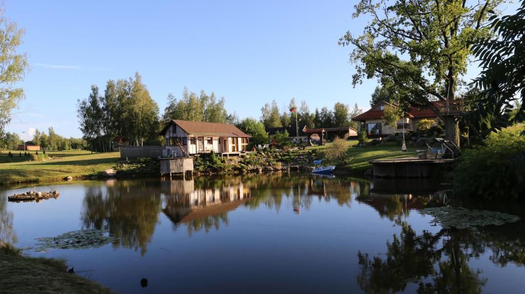 a lake with a house and a house at Residence R&R in Karvys