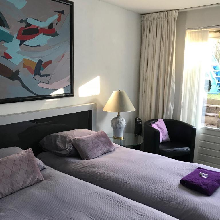 a hotel room with a bed and a chair at Villa 't Haasduin in Wijk aan Zee