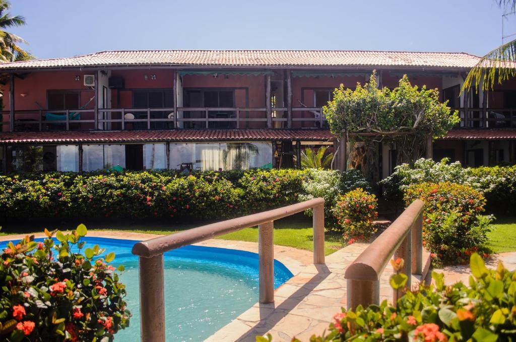 un complexe avec une piscine et un bâtiment dans l'établissement Hotel Porto do Zimbo, à Morro de São Paulo