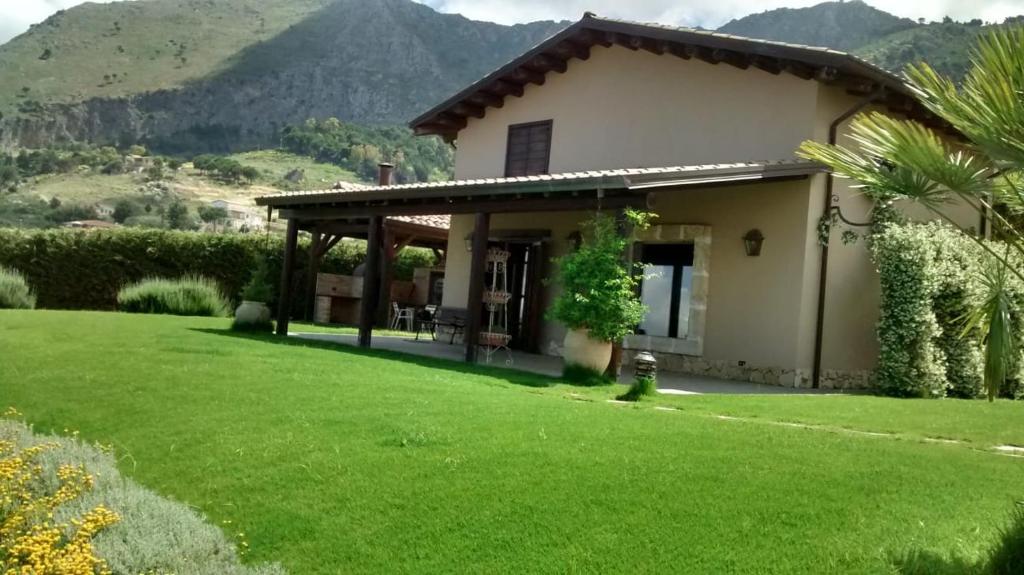 a house with a green lawn in front of it at Sicilia tra cielo e mare con piscina in Palermo