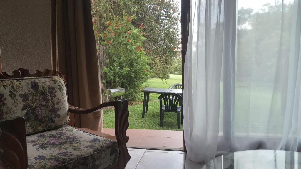 a chair and a window with a view of a yard at 2 Bedroom Cottage in Midrand