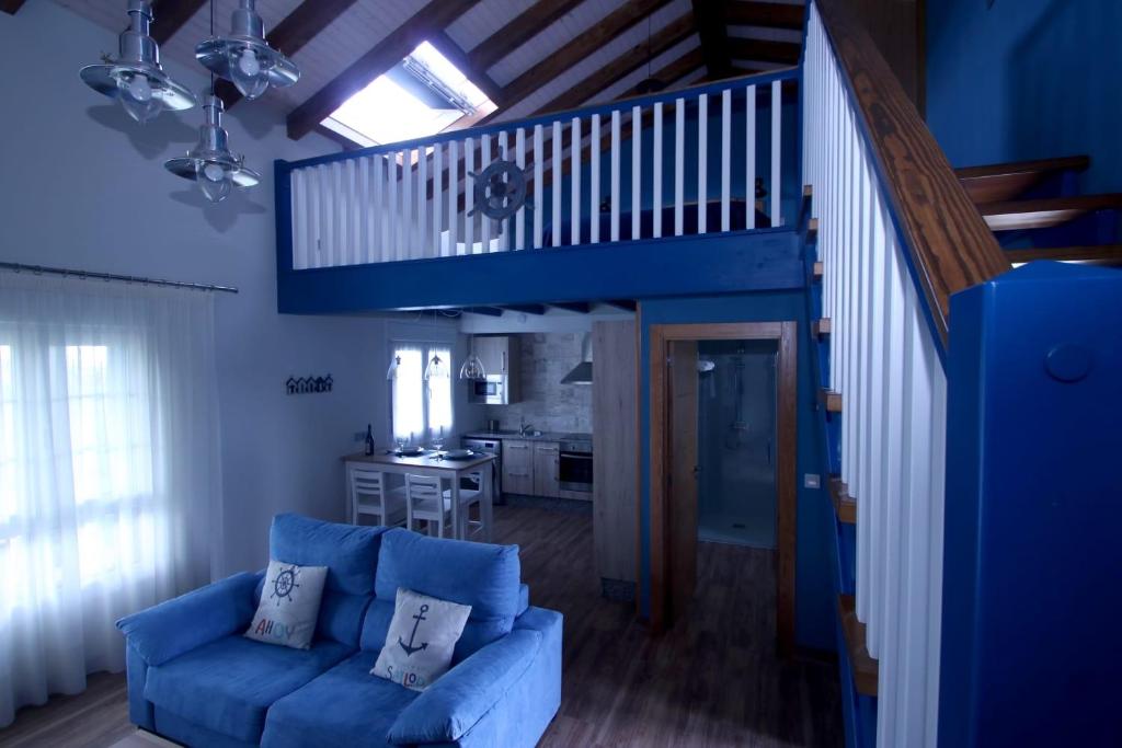 a living room with a blue couch and a staircase at Playas de Luarca in Barcia