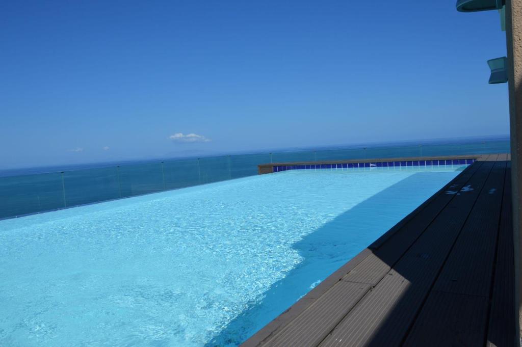 een zwembad met de oceaan op de achtergrond bij Castelsardo Miramare 10 - 6 posti in Castelsardo