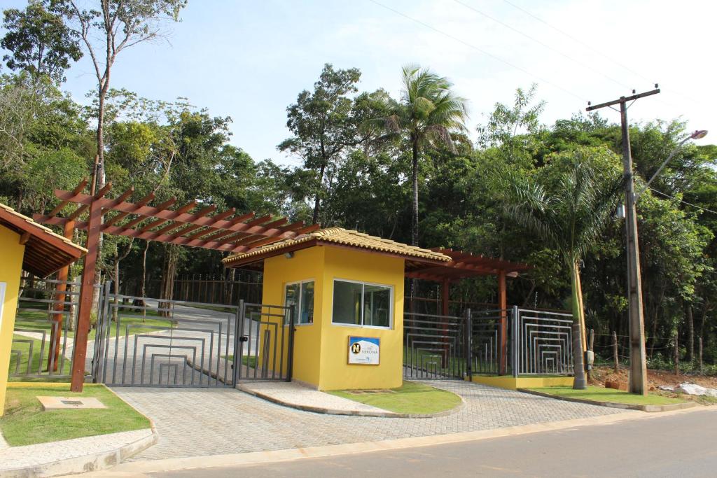 um pequeno edifício amarelo com um portão num parque em Villa Verona em Praia do Forte