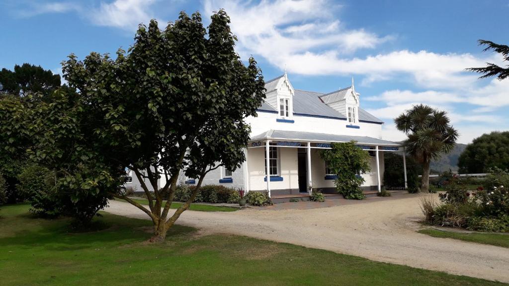 a white house with a tree in front of it at Western House B&B Kurow in Kurow