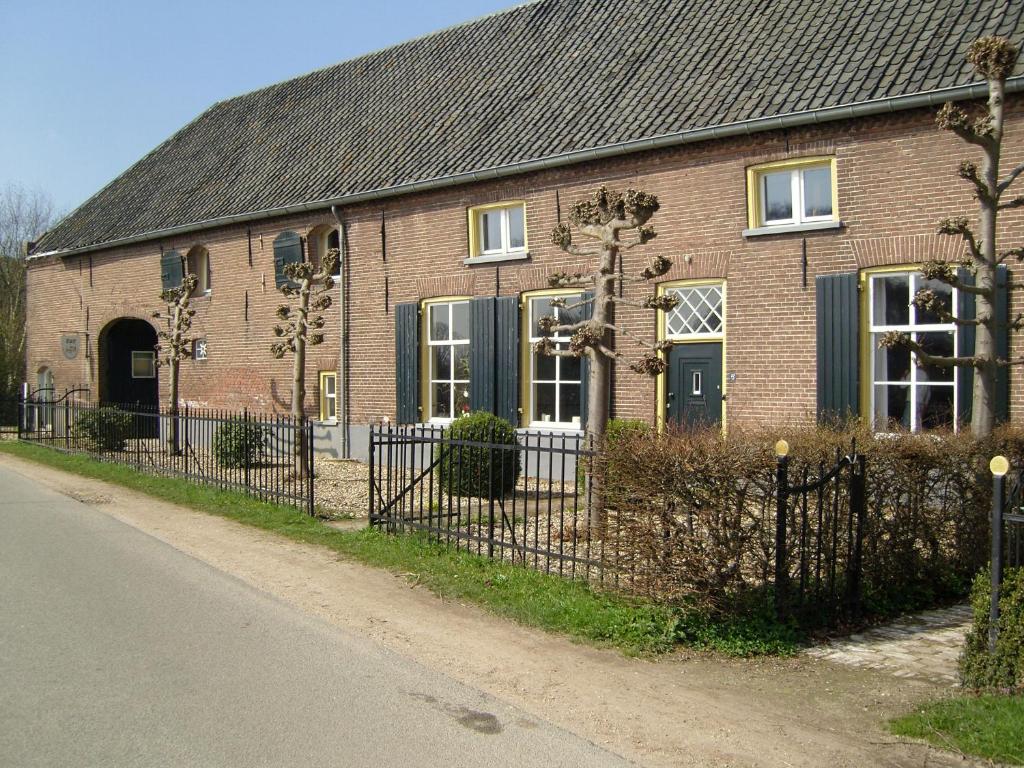 een stenen huis met een hek ervoor bij Bed & Breakfast Appeltern in Appeltern