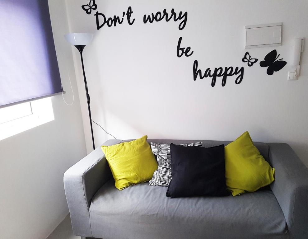 a gray couch with yellow pillows in a living room at Casa Io - Djeu in Mindelo