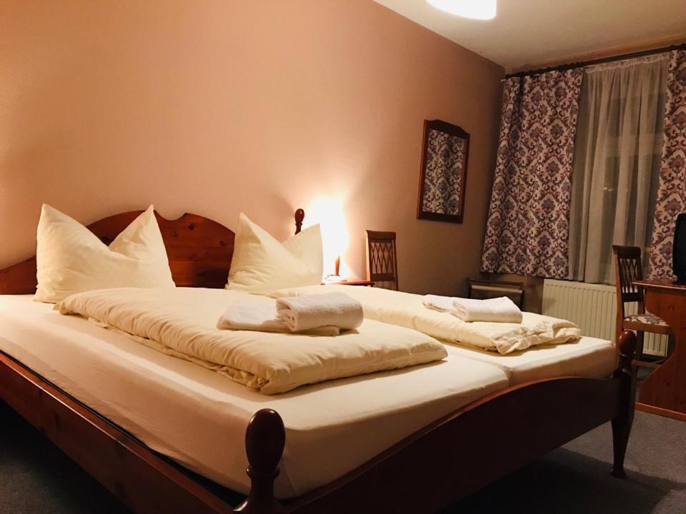 a bedroom with a large bed with white pillows at Haus Schlematal Hotel und Restaurant in Bad Schlema