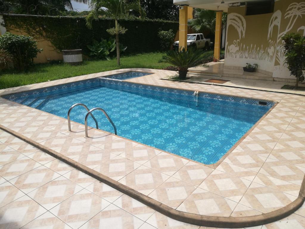 a swimming pool in a yard with a tile floor at Dorado Hotel in Cobija