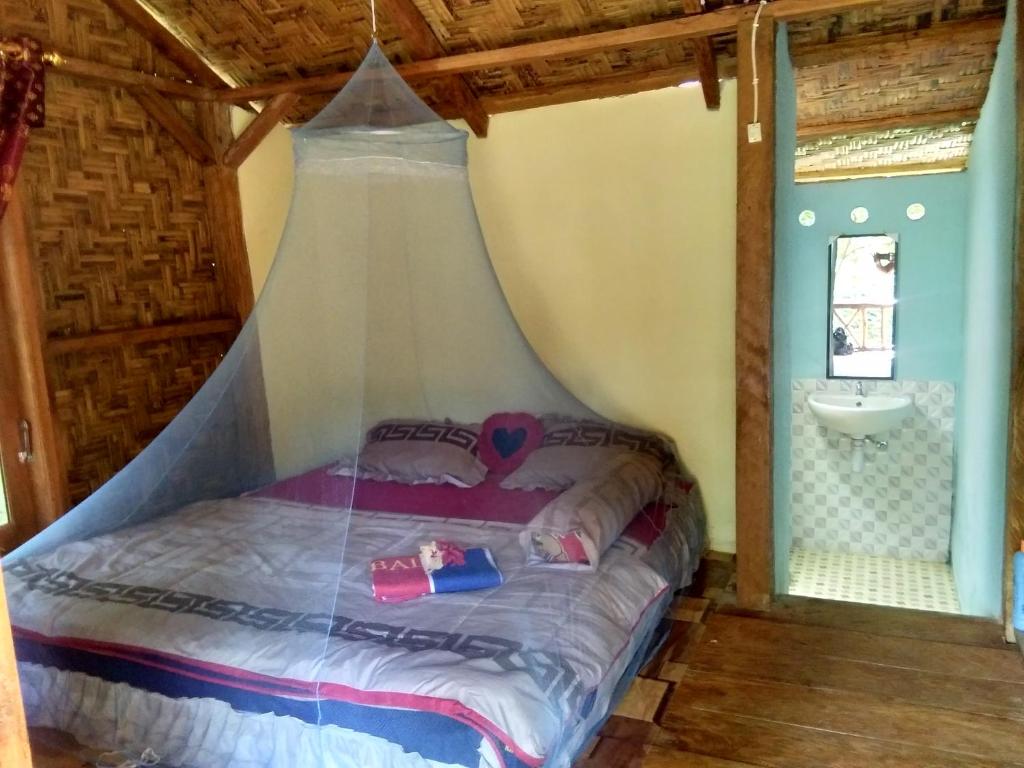 Tempat tidur dalam kamar di Bukit Lawang Landak River Guest House