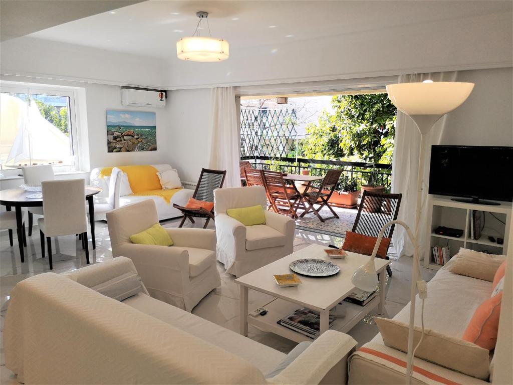 un soggiorno con divani bianchi e tavolo di Cozy Three Bedroom Apartment in Varkiza a Vari