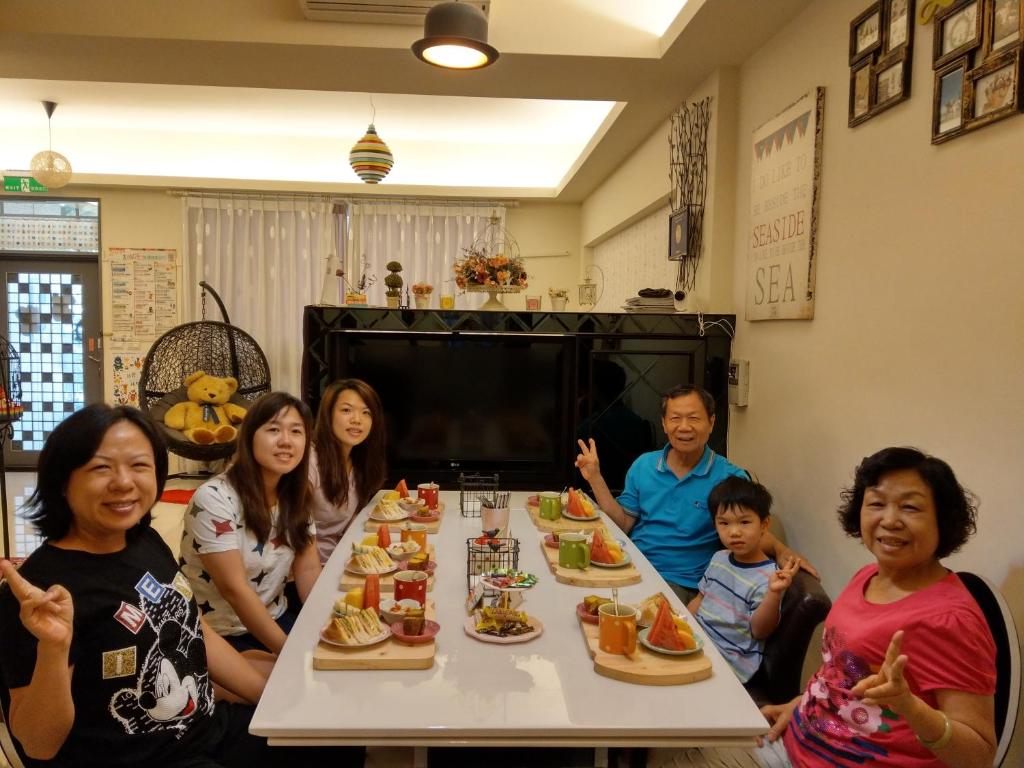 a group of people sitting around a table eating food at Sweet Rainbow B&amp;B in Hualien City