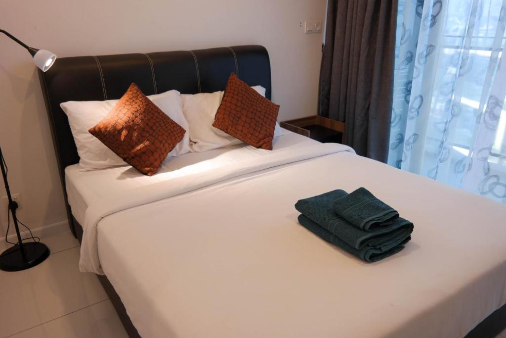 Summersuites by AG Vacation WiFi Twin Tower في كوالالمبور: غرفة نوم عليها سرير وفوط خضراء