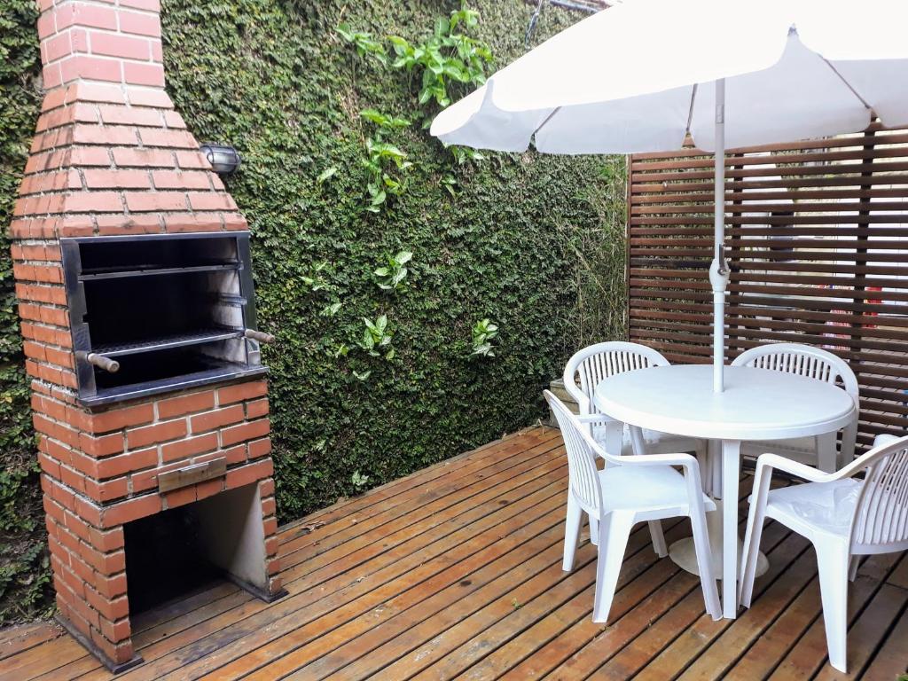 a patio with a table and an outdoor oven at Casa em condomínio in Barra do Sahy