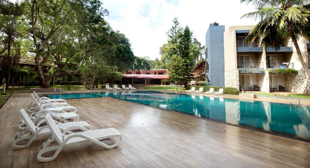 a swimming pool with lounge chairs next to a building at Miridiya Lake Resort in Anuradhapura