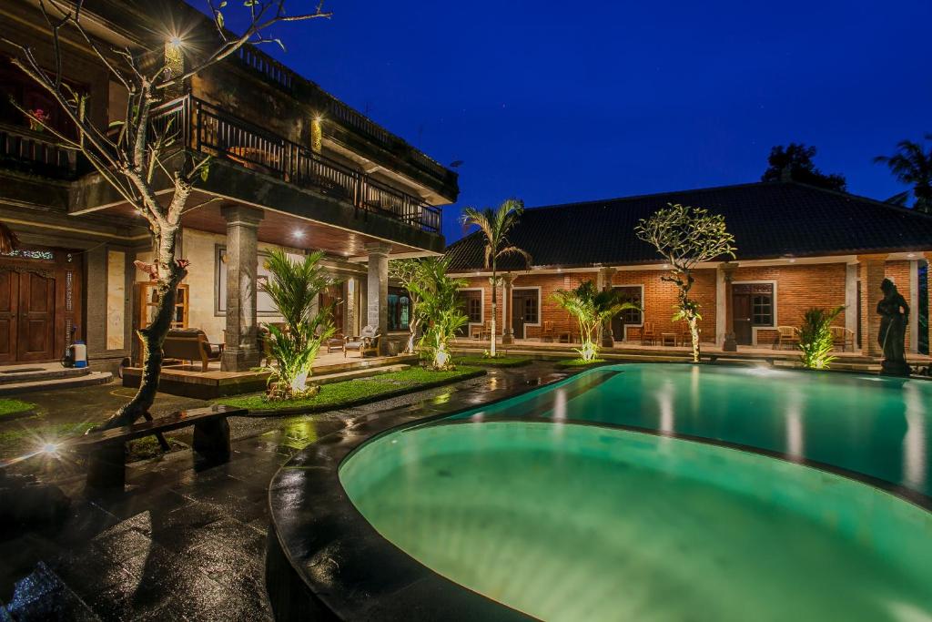 uma piscina em frente a uma casa à noite em The Lumbung Jaya by Uniquecations em Tegalalang