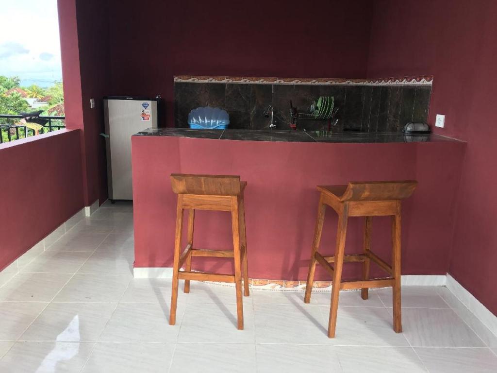 金巴蘭的住宿－德思德考斯特巴厘島民宿，厨房配有2张凳子和带水槽的台面