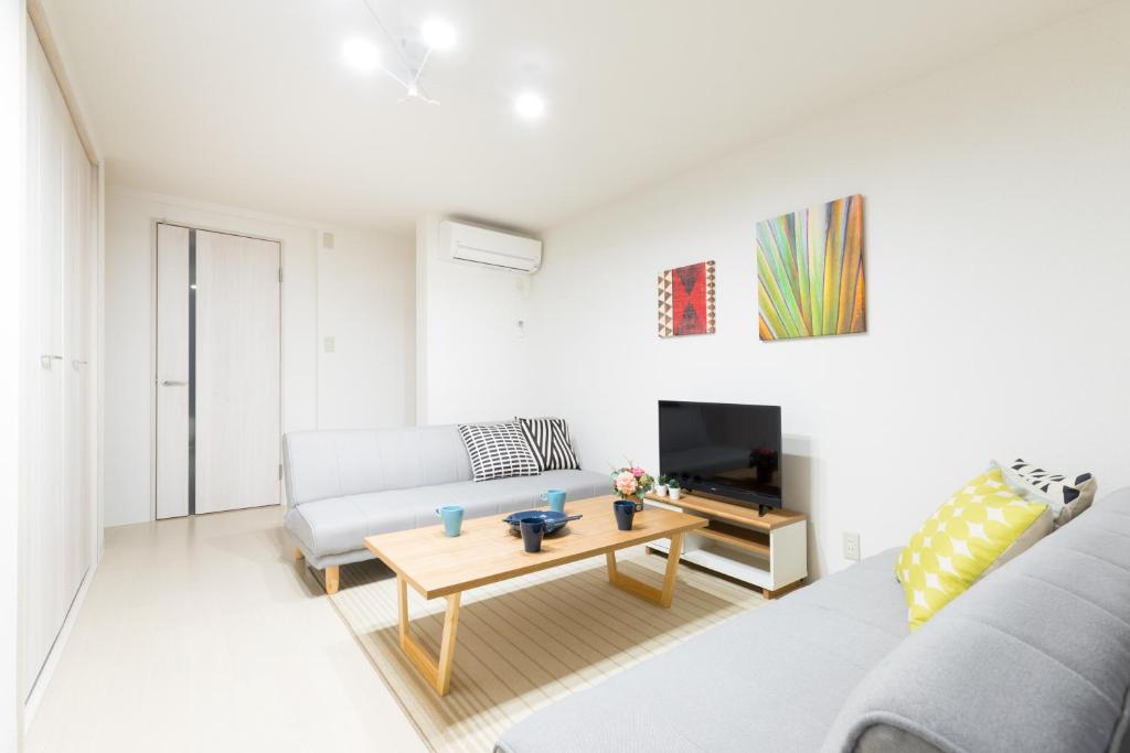 a living room with a couch and a table at Momodani House 501 in Osaka