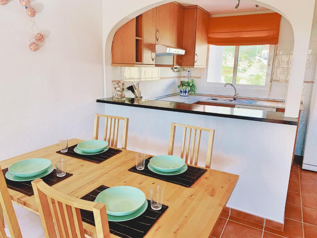 拉佐宜亞的住宿－AOTEAROA，厨房以及带木桌和椅子的用餐室。