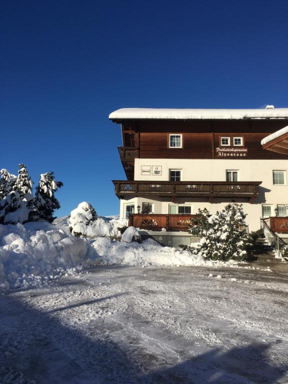 un gran edificio con nieve delante en Frühstückspension Alpenrose Bed & Breakfast en Iselsberg