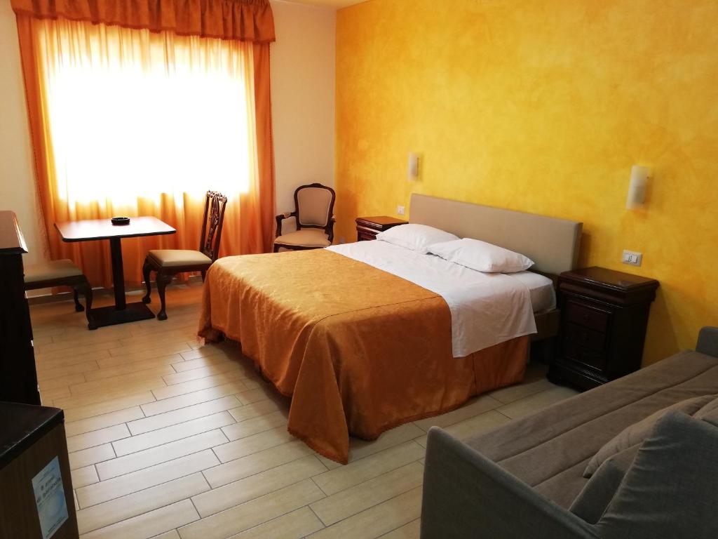 ボスコレアーレにあるHotel La Velaのベッドとソファ付きのホテルルーム