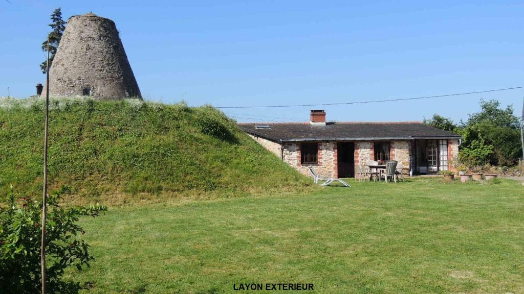 een oud stenen huis met een grasheuvel ernaast bij Gîte Layon 6 places Moulin de la Placette in Faye-dʼAnjou