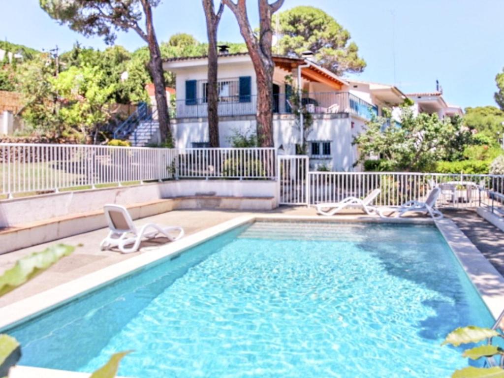 una piscina con 2 tumbonas junto a una casa en VACAY Villa alzines, en L'Escala