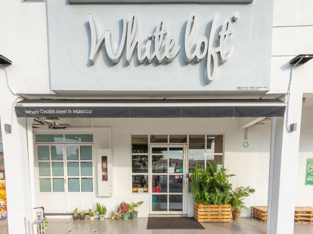 ein weißes Losschild auf der Vorderseite eines Ladens in der Unterkunft White Loft Hotel in Malakka