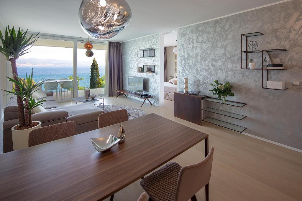 a living room with a table and a living room with a couch at Opatija Deluxe Apartment with swimming pool in Opatija