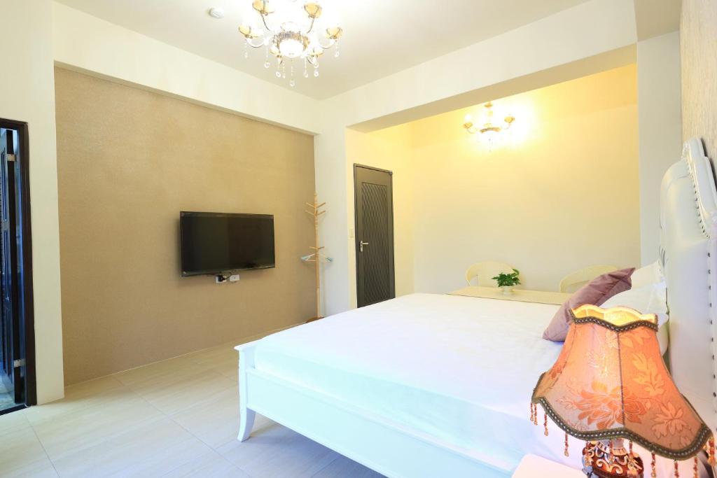 a bedroom with a large bed with a tv on the wall at 花蓮漫漫時光電梯包棟民宿 in Hualien City