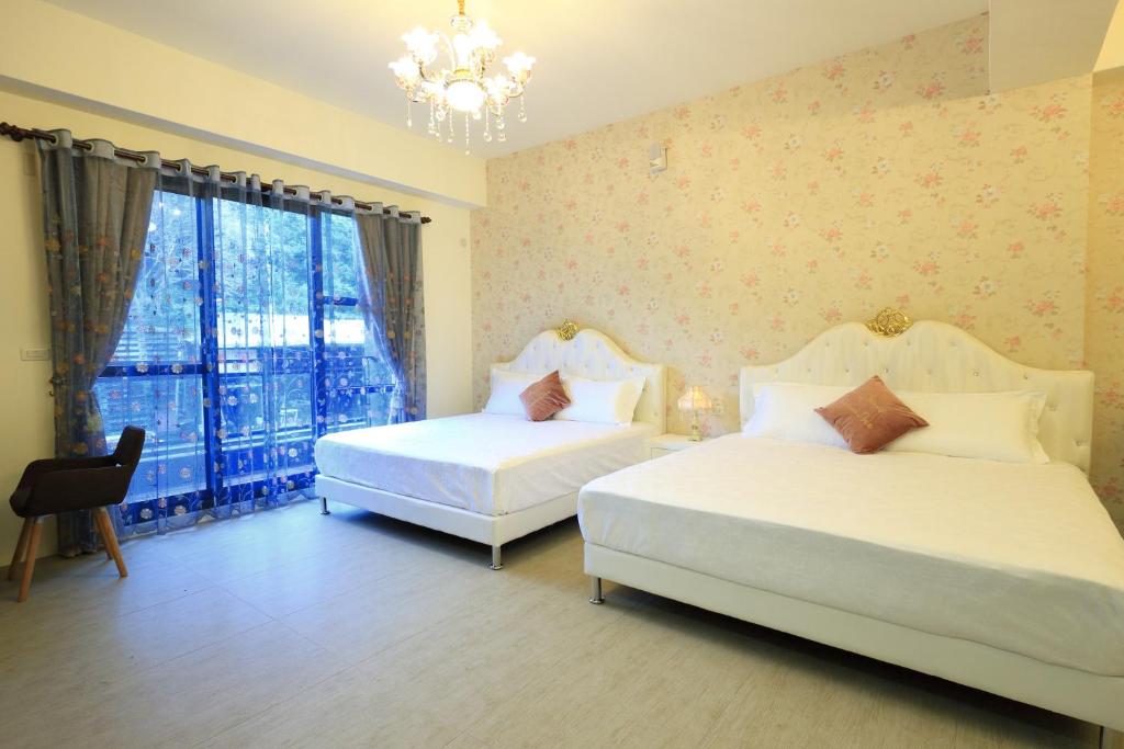 a bedroom with two beds and a window at 花蓮漫漫時光電梯包棟民宿 in Hualien City