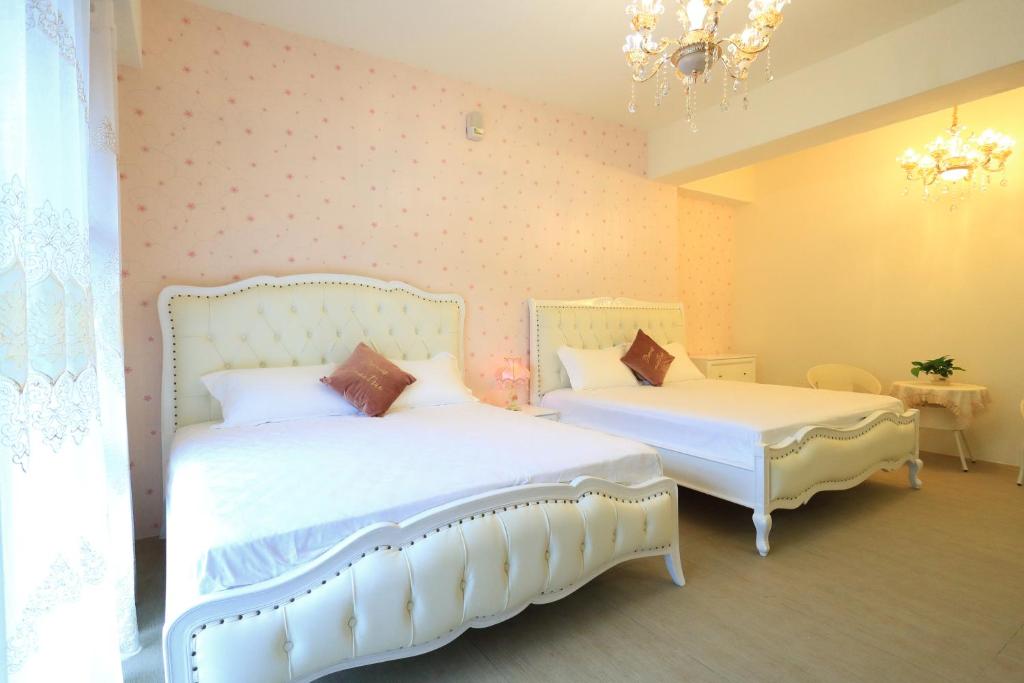 a bedroom with two beds and a chandelier at 花蓮漫漫時光電梯包棟民宿 in Hualien City