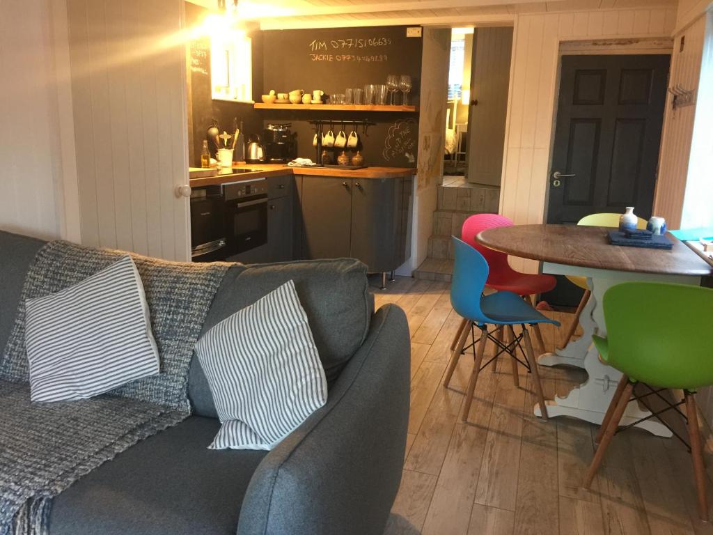 a living room with a couch and a table with chairs at The Boathouse in Carbis Bay