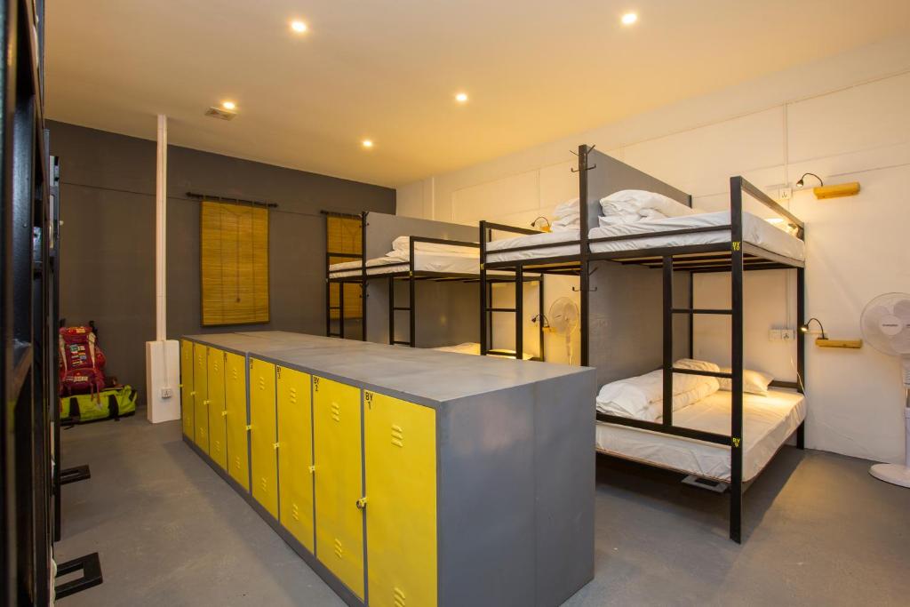 a room with four bunk beds and yellow cabinets at Yakety Yak Hostel in Kathmandu