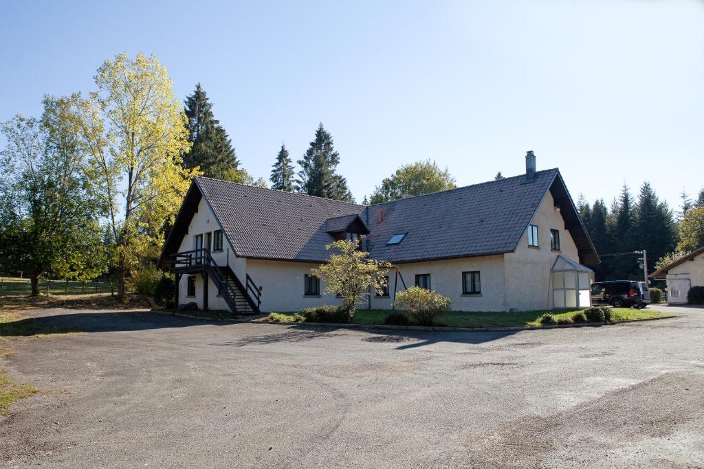 une grande maison blanche avec un toit noir dans l'établissement Gîte Les Baudy, à Servance