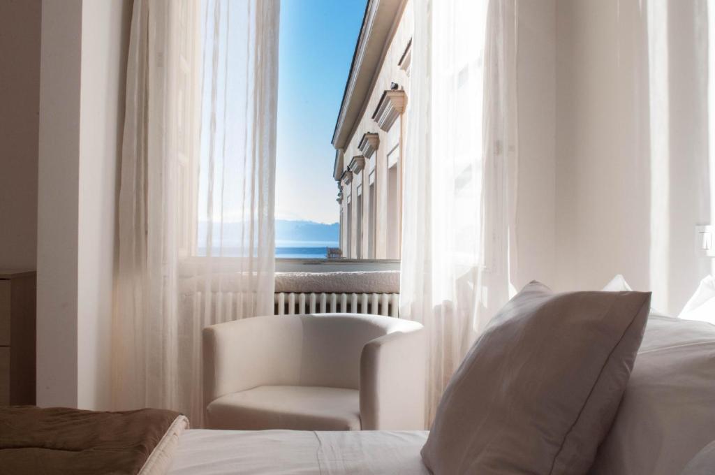 1 dormitorio con silla, cama y ventana en Hotel Terme Neronensis, en Pozzuoli