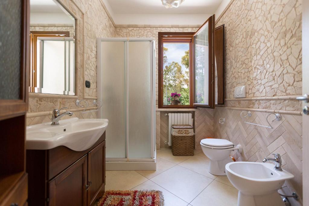 łazienka z umywalką, toaletą i prysznicem w obiekcie Villa Pizzi by Perle di Puglia w mieście San Donaci