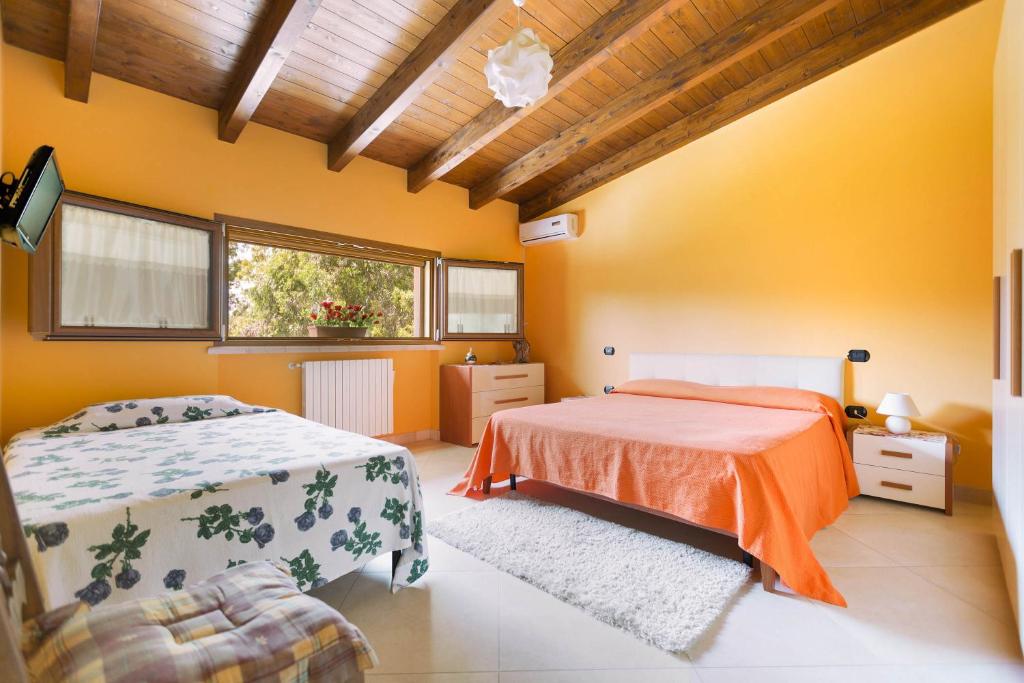 sypialnia z dwoma łóżkami i oknem w obiekcie Villa Pizzi by Perle di Puglia w mieście San Donaci