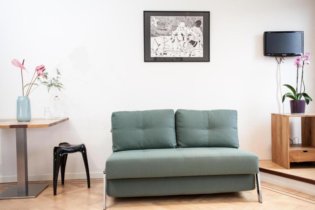 a green chair in a living room with a table at Kuwadro Guesthouse Centrum in Amsterdam