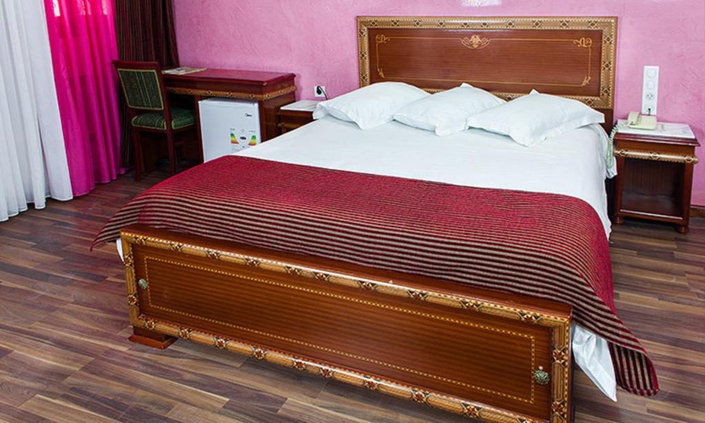 a bedroom with a large bed with a wooden headboard at DAR DIAF CHERAGA in Alger