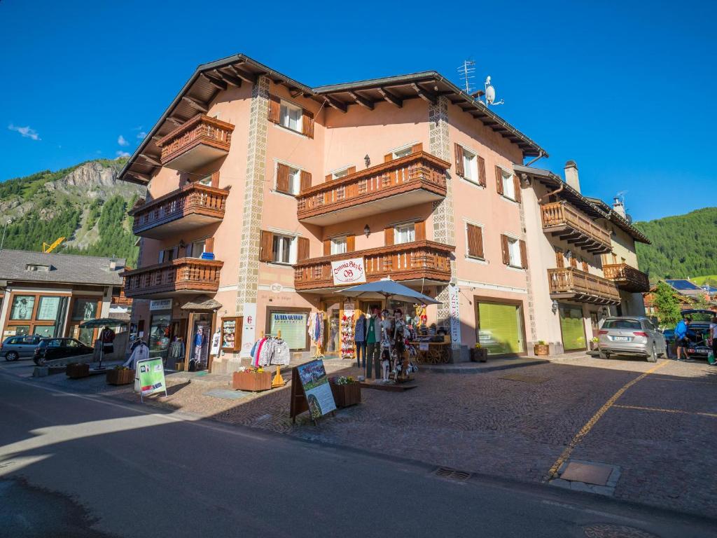 a large building with wooden balconies on a street at Maison Ostaria MyHolidayLivigno in Livigno