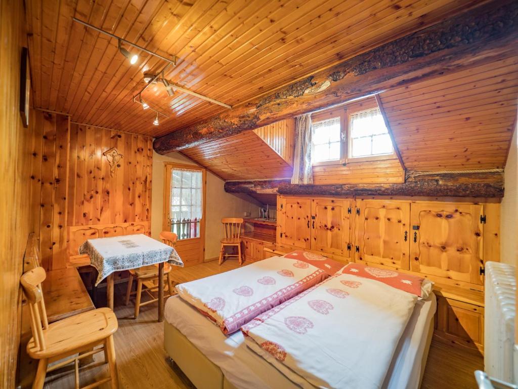ein Schlafzimmer mit einem Bett in einer Holzhütte in der Unterkunft Apartments & Rooms MyHolidayLivigno in Livigno