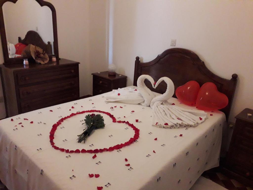 a bed with two swans made out of hearts at Casa Feijao - Alojamento Local in Geres