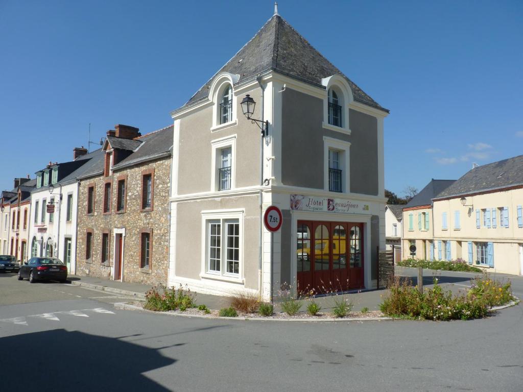 a large white building on the corner of a street at Beauséjour in Sainte-Suzanne