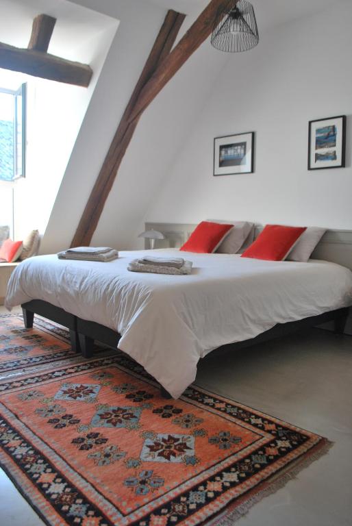 a bedroom with a large bed with a rug at Natangora in Marcillac-Vallon
