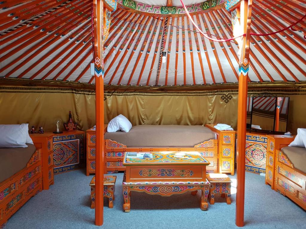 a room with two beds and a table in a yurt at Pension New Nomads in Zesch