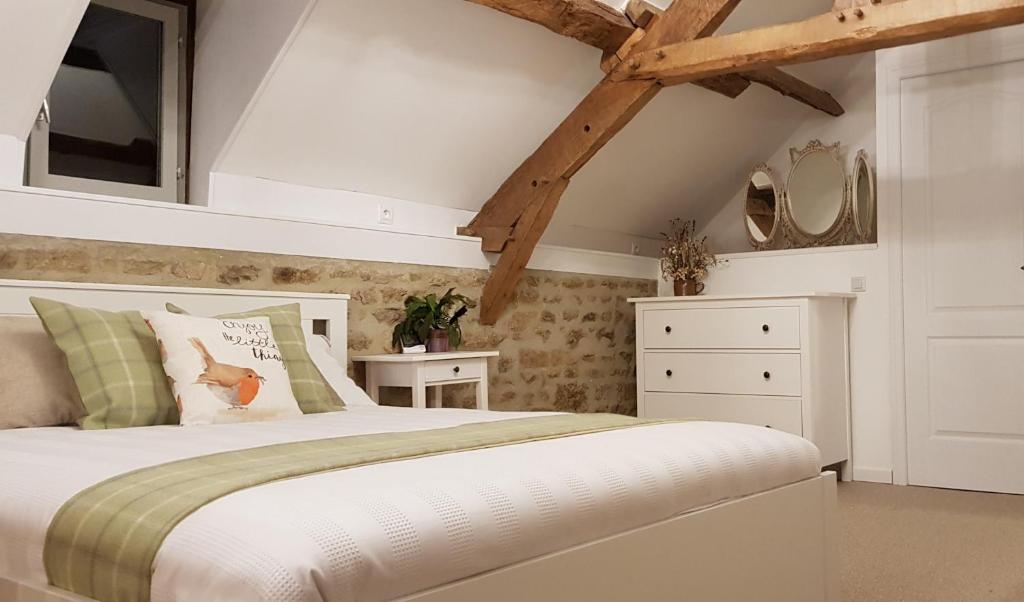 um quarto com uma cama branca e uma cómoda branca em De La Terre Farm Stay em Lignieres-Orgeres