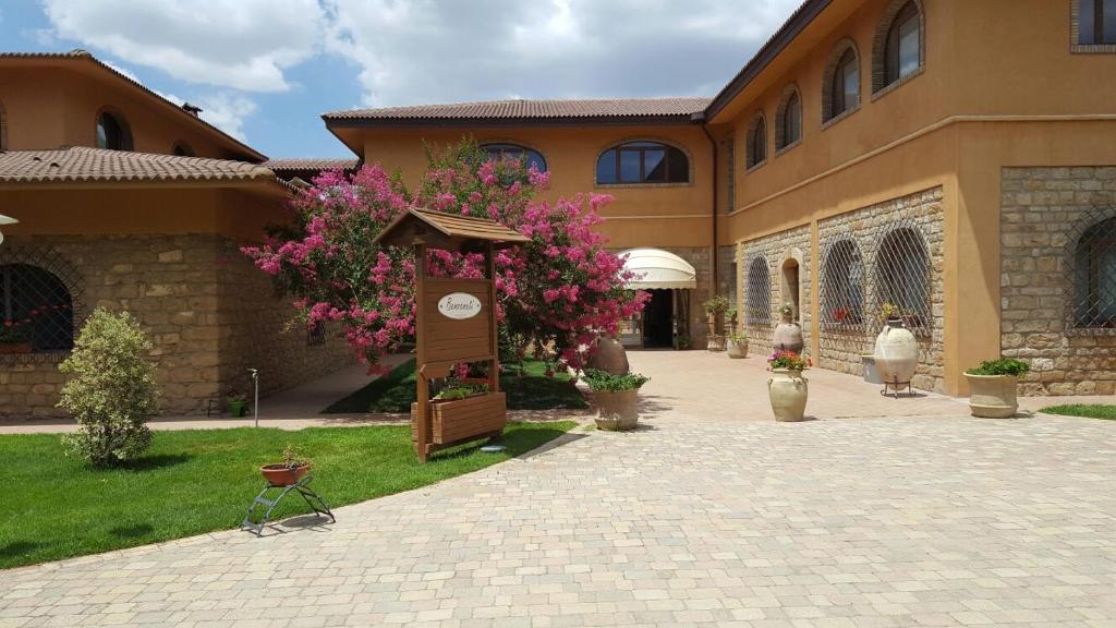 a building with a sign and flowers in front of it at Agriturismo Il Drago in Piazza Armerina