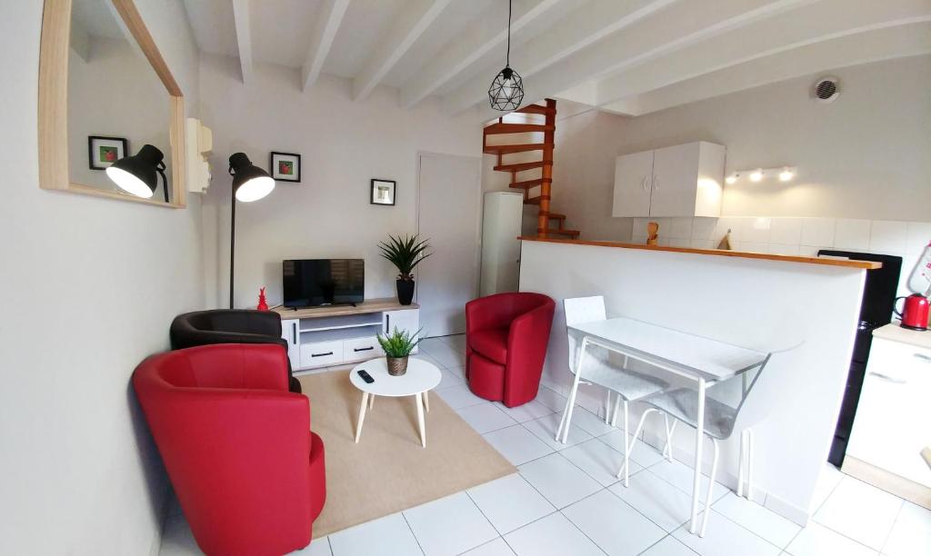 sala de estar con sillas rojas y mesa en Maisonette en HYPERCENTRE calme avec terrasse, en Cholet